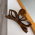 Detail shot of a large acetate hair claw clip featuring a 3D bow design in tortoiseshell - Maillard Brown
