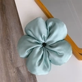 Detail eines minzgrünen Satin-Haargummis mit seidiger Textur und großem Blumendesign - Grün