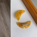 Vue détaillée des barrettes banane en acétate jaune avec pinces métalliques dorées - Sandwich En Forme De Banane