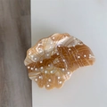 Macro view of shell-shaped acetate hair claw with golden spiral lines and marble texture - Conch Claw Clip / Brown