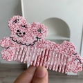 Dettaglio del pettine in acetato marmorizzato rosa con simpatiche faccine a fumetti - 12cm x 7cm / Rosa