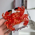 Grande pince à cheveux crabe en acétate avec motif marbré orange et détails dorés - Pince Crabe Rouge