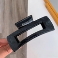 Gros plan sur une grande pince à cheveux rectangulaire avec un motif de marbre gris foncé - Texture Noire