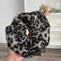 Detail of grey leopard print scrunchie showing faux leather texture and large pleats - Black Leopard