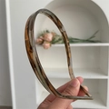 Nahaufnahme eines schmalen Acetat-Haarreifens mit klassischem braunem Schildpattmuster - Braun Grün