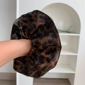 Close-up of leopard print PU leather hair scrunchie with detailed animal pattern texture - Coffee Leopard