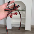 Dettaglio dell'elastico per capelli con fiocco a righe e ciondoli a ciliegia - Stile Ciliegia a Strisce Rosse e Verdi
