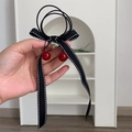Dettaglio di elastico per capelli nero con fiocco a pois e ciondoli a ciliegia rossi - Stile Ciliegia Nera