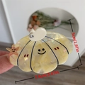 Shell-shaped acetic hair claw in creamy pearl finish with smiley and star detail - Yellow