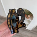 Detail der Haarklammer aus Acetat mit Schildpattmuster und abstraktem Augen-Design - Schwarzes Schildpatt-Augenmuster