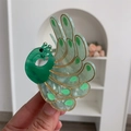 Detalle de pinza para pelo de pavo real con textura de mármol verde y bordes dorados - Pinza Pavo Real Verde