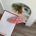 Dettaglio del fermaglio per capelli in acetato rosa con fiocco 3D e strass centrale - Rosa