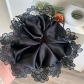 Dettaglio di un grande elastico in raso nero con bordo in pizzo e trama a pieghe - Nero (Diametro 18cm Peso 34g)