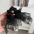 Detail of black lace scrunchie showing fine mesh texture and layered floral design edges - Black
