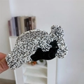 Détail d'une pince à cheveux en acétate faite main avec motif chat noir et texture tachetée - Style Phoque Noir et Blanc