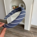 Detalle de diadema acolchada de tela a rayas azules y blancas sostenida a mano - Azul Marino Sarga Ancha