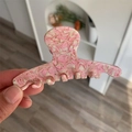 Close-up of pink peach texture acetate hair claw clip with marble finish and smooth teeth - 10cm x 4cm