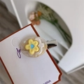 Détail d'une barrette ovale en acétate avec motif fleur jaune et petit oiseau blanc - Jaune