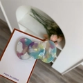 Detail of candy-colored acetate hair clip with tie-dye marble texture on display card - Colorful