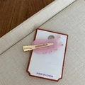 Detaillierte Nahaufnahme einer rosa flügelförmigen Acetat-Haarspange mit Strass - Hellrosa Seitenclip