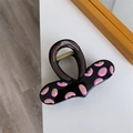 Detailopname van een grote zwarte haarklem van hars met roze en groene abstracte stippen - Roze en Groen