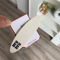 Close-up of cream matte oval hair clip with black nyu nyu lettering on display card - Creamy White Oval