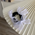 Detail of sweet black hair scrunchie with delicate white lace bows for elegant hairstyles - White