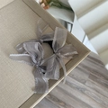 Detailed close-up of light gray organza double bow hair scrunchie with high elastic band - Gray