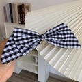 Detailansicht der handgehaltenen Vintage Haarklammer mit schwarz-weißem Karomuster - Schwarz