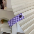 Détail d'une pince à cheveux à fleurs à carreaux violets sur un éventail blanc - Carreaux Violet