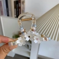 Detail of sweet floral hair claw clip with colorful crystal beads and shell-like petals - White