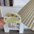 Primer plano de una pinza para el pelo con forma de hongo y textura de acetato colorida - Pinza de Seta Amarilla