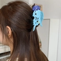 Dettaglio della pinza per capelli a forma di medusa blu e viola su capelli castani - Forma Medusa Blu