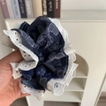 Close-up of a blue floral scrunchie with white lace trim being held by hand - Blue 3D Scrunchie