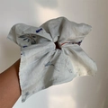 Nahaufnahme eines großen cremefarbenen Haargummis mit blauen und roten Blumenstickereien - Grauer Bestickter Quadratischer Scrunchie