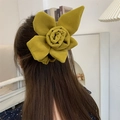 Close-up of a large mustard yellow velvet floral hair tie worn on a stylish ponytail - Flower Style / Yellow