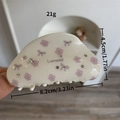 White resin hair claw clip with purple floral patterns and sparkling rhinestones - Floral Dumpling Clip