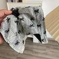 Dettaglio del tessuto grigio traslucido con stampe di fiocchi neri e trama a righe - Grigio con Fiocco
