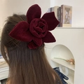 Burgundy velvet flower hair clip shown on back view of model with long brown hair - Flower Style / Retro Red