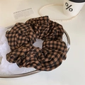 Retro-Haargummi mit braunem Karomuster und weichen Stofffalten auf Tablett - Karamell Kariertes Scrunchie