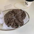 Detailaufnahme eines braun gestreiften Stoff-Haargummis in einem ästhetischen Metallkorb - Graubraun Streifen Scrunchie
