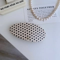 Détail de la barrette ovale en acétate à pois avec l'inscription Barrette la France - Blanc avec Points Noirs