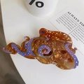 Detail of octopus hair claw with blue tentacles and amber acetate texture on white desk - Brown Large Octopus Claw