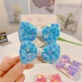 Pair of light blue bow hair clips with floral sequins for girls on a fashion display card - Sky Blue