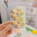 Dettaglio di fermagli per capelli a fiore in tessuto giallo con paillettes e perle finte - Molletta BB Gialla