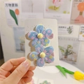 Détail de pinces à cheveux fleurs en maille bleue avec motifs floraux et perle jaune - Pince Bec de Canard Bleue