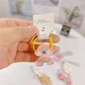 Detail of yellow spiral hair tie with glittery rainbow charms for young girls - Rainbow