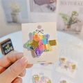 Macro shot of colorful rainbow star hair clip with gold glitter center on card - Dark Colorful Star