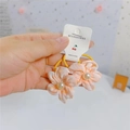 Dettaglio di elastici per capelli a fiori rosa con perle su carta in mano - Elastico per Capelli a Fiore Rosa Arancio