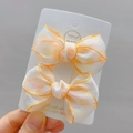 Detailed macro view of handmade polka dot bow hair clips with delicate orange piping edge - Orange Hair Clips (a Pair)